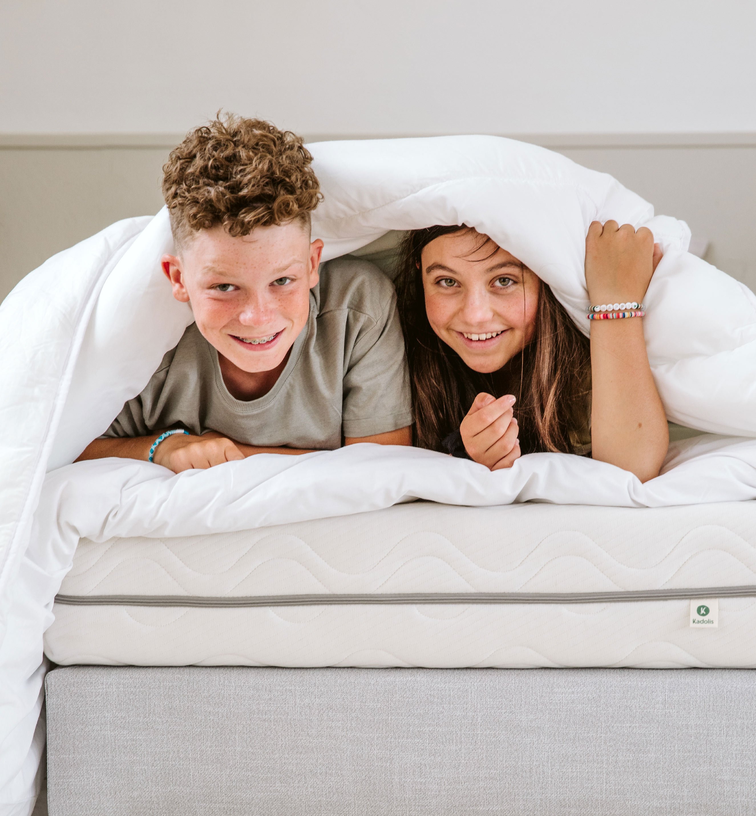 Children in bed under a comforter